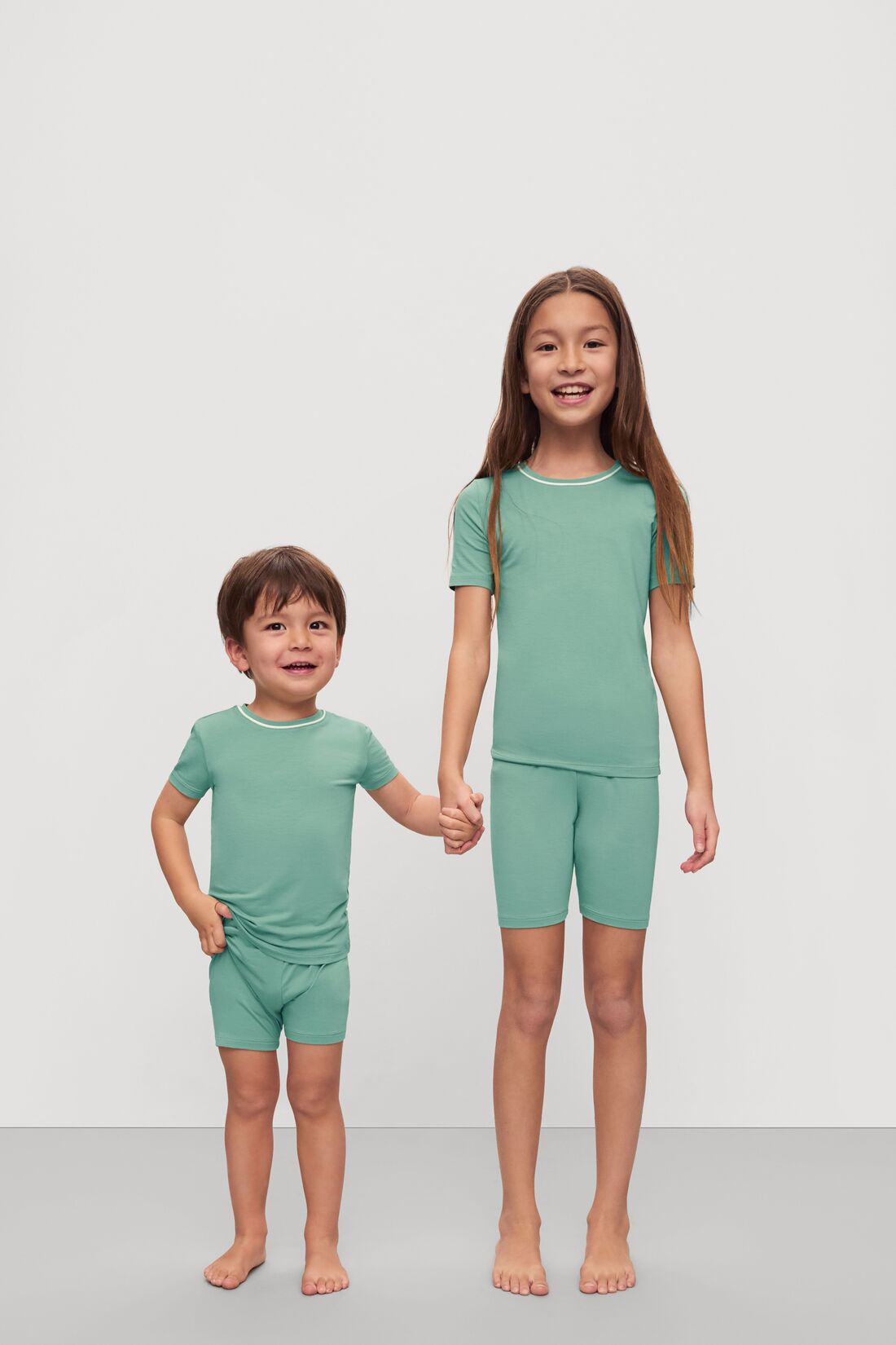 Model is wearing Kids TENCEL™ Modal Unisex Short PJ Set in Seagrass/White