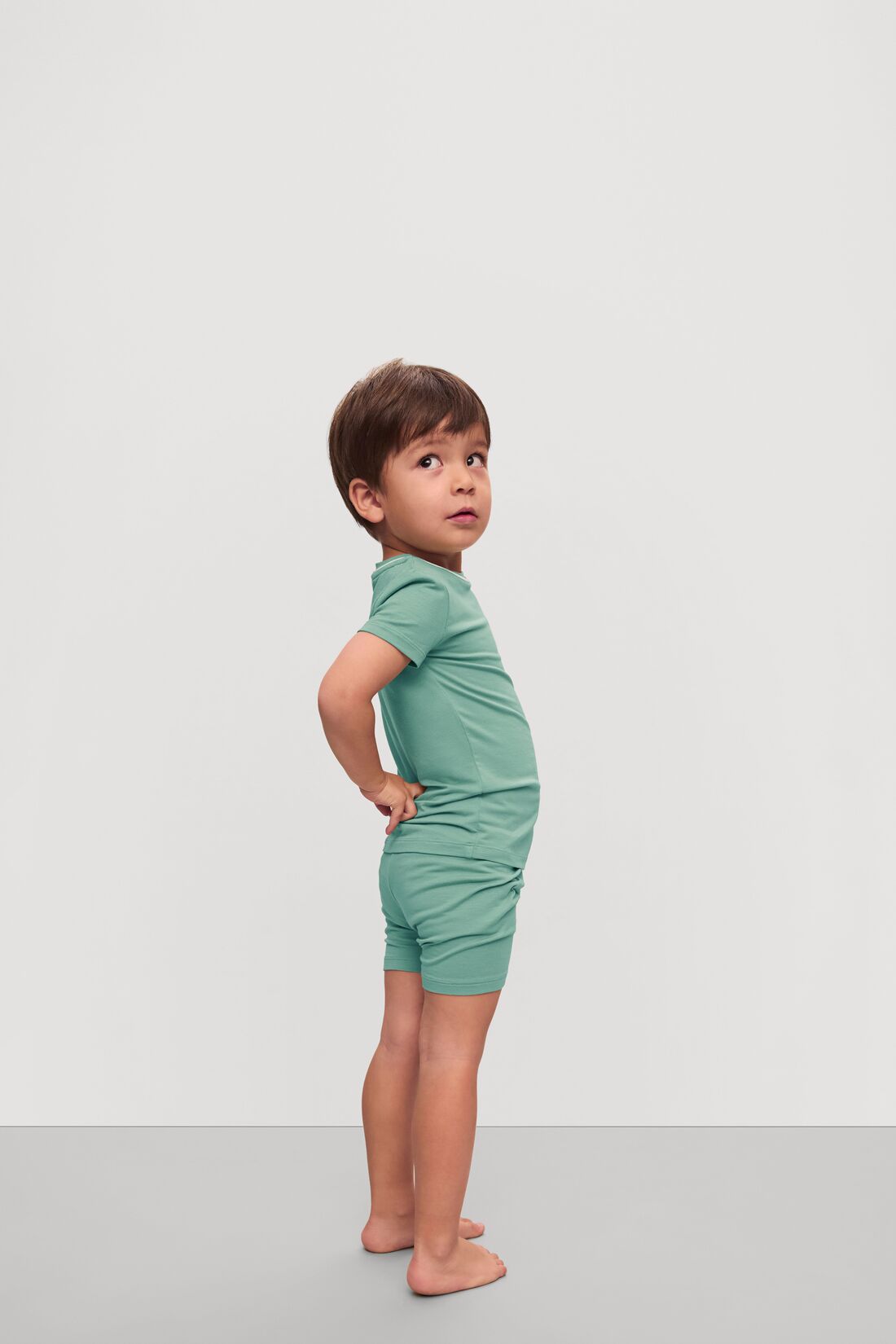 Model is wearing Kids TENCEL™ Modal Unisex Short PJ Set in Seagrass/White