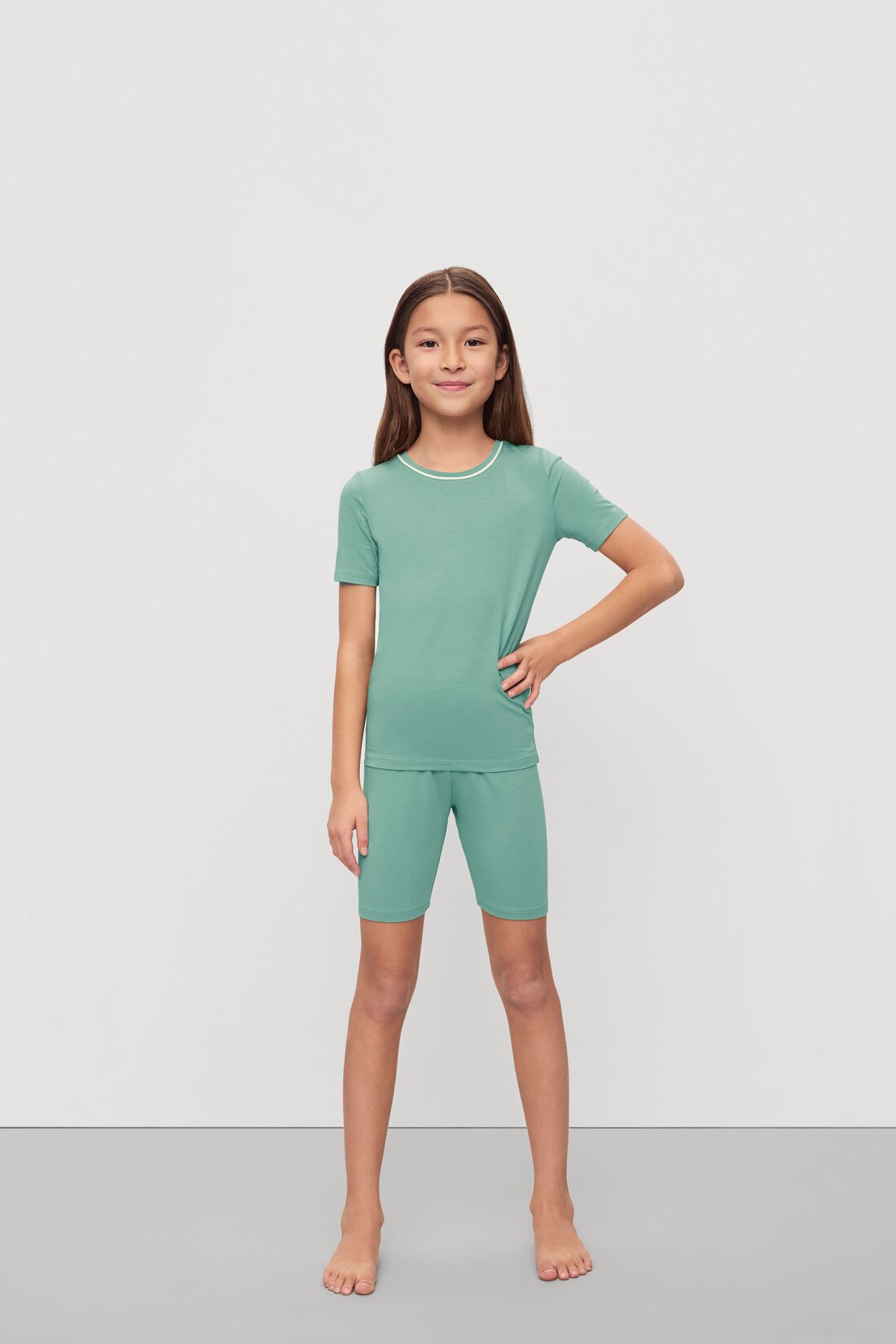 Model is wearing Kids TENCEL™ Modal Unisex Short PJ Set in Seagrass/White