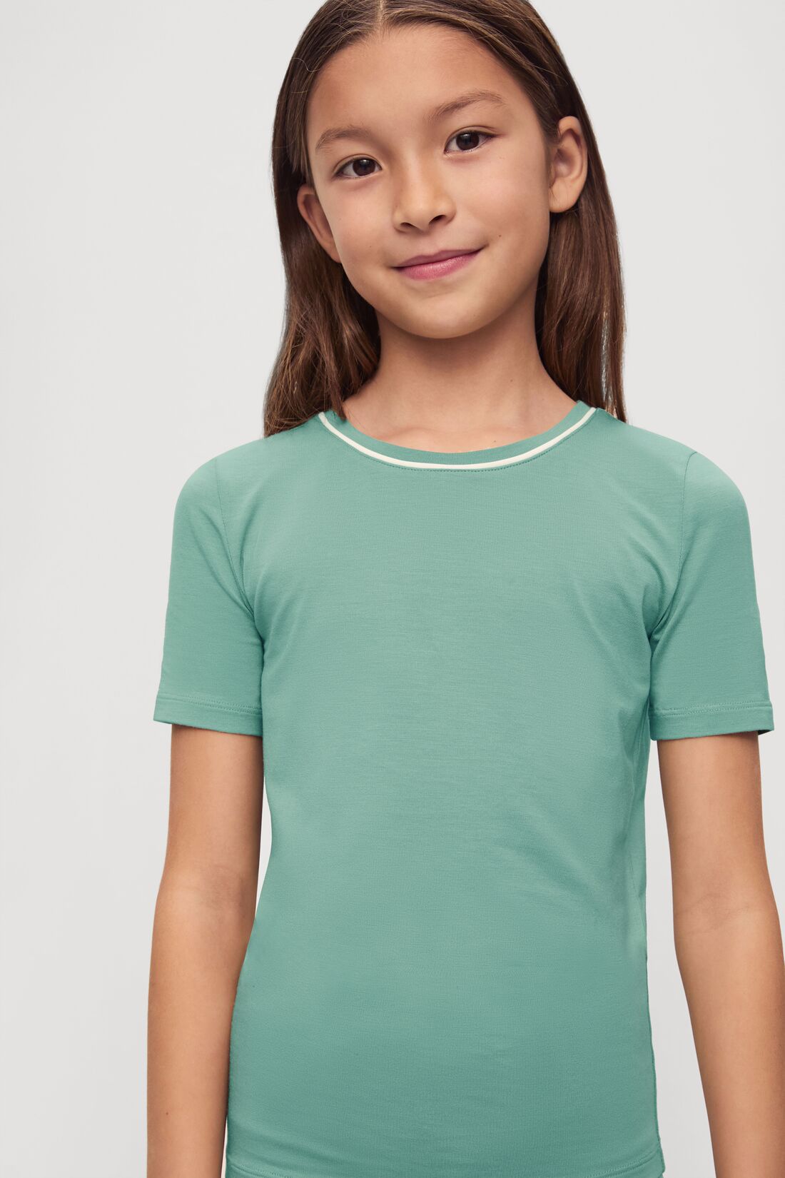 Model is wearing Kids TENCEL™ Modal Unisex Short PJ Set in Seagrass/White