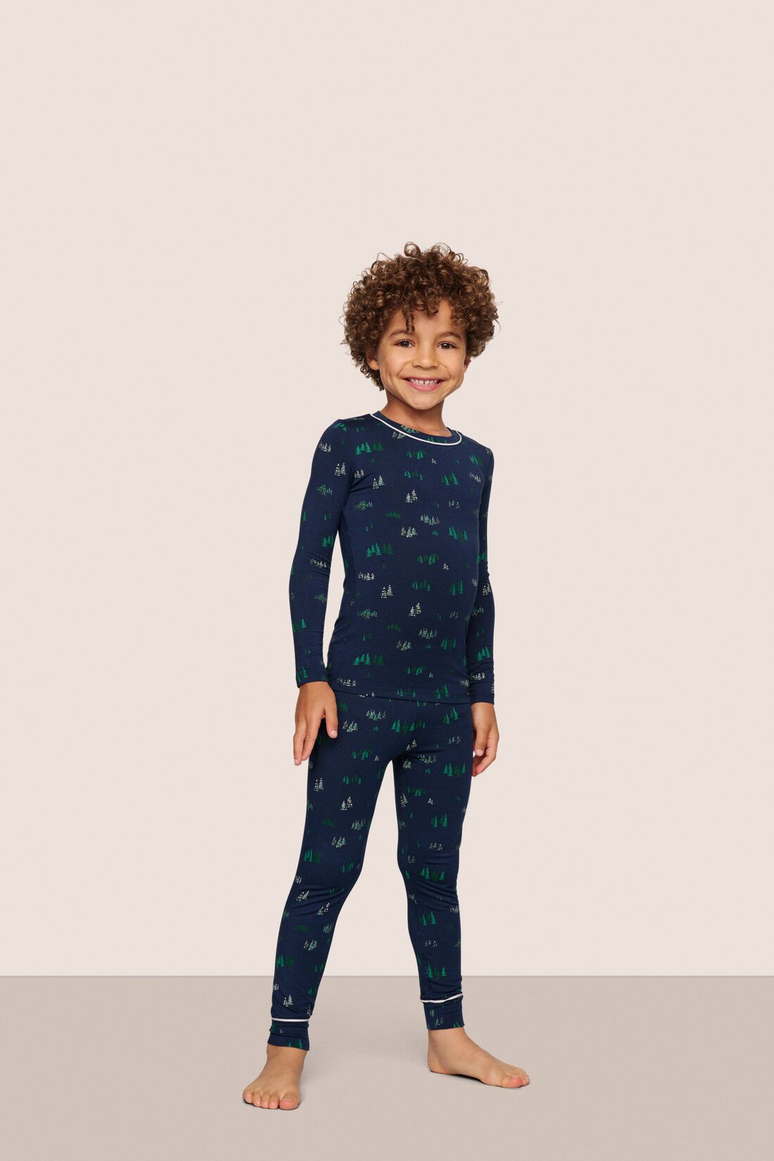 Model is wearing Kids Printed TENCEL™ Modal Unisex Long PJ Set  in Forest Pine Navy/Ivory