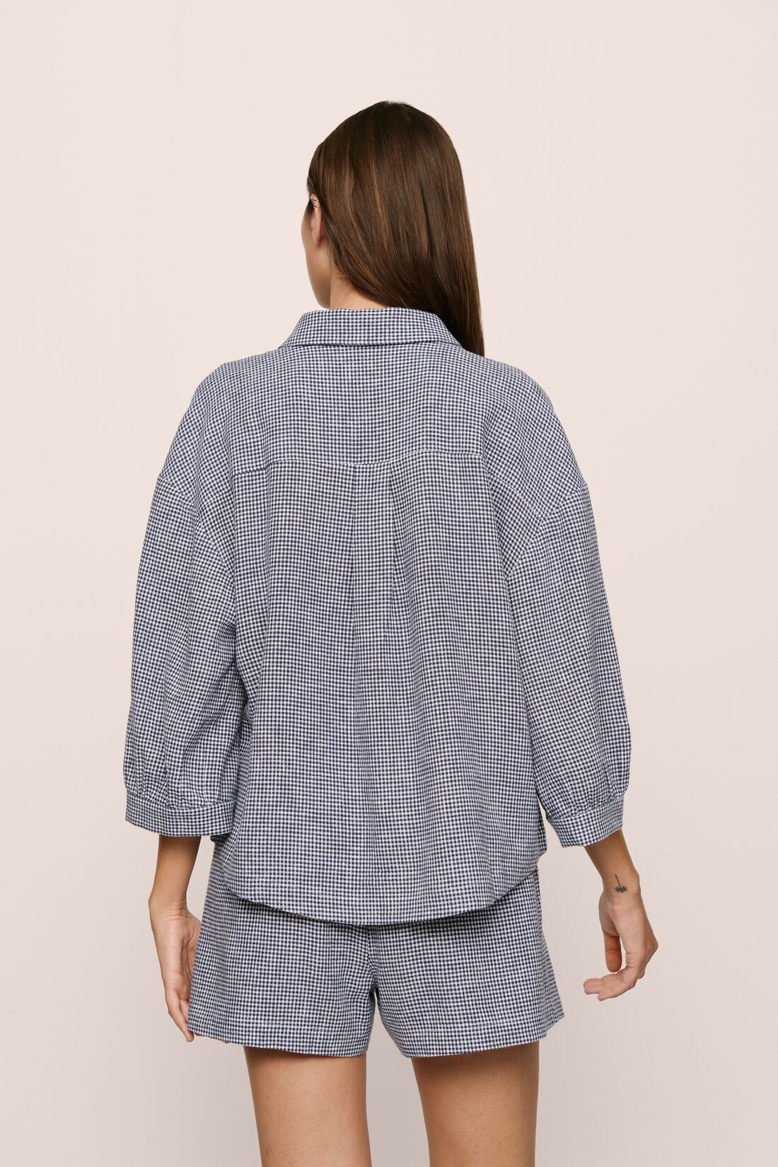 Model is wearing relaxed quarter sleeve  top in gingham white/navy