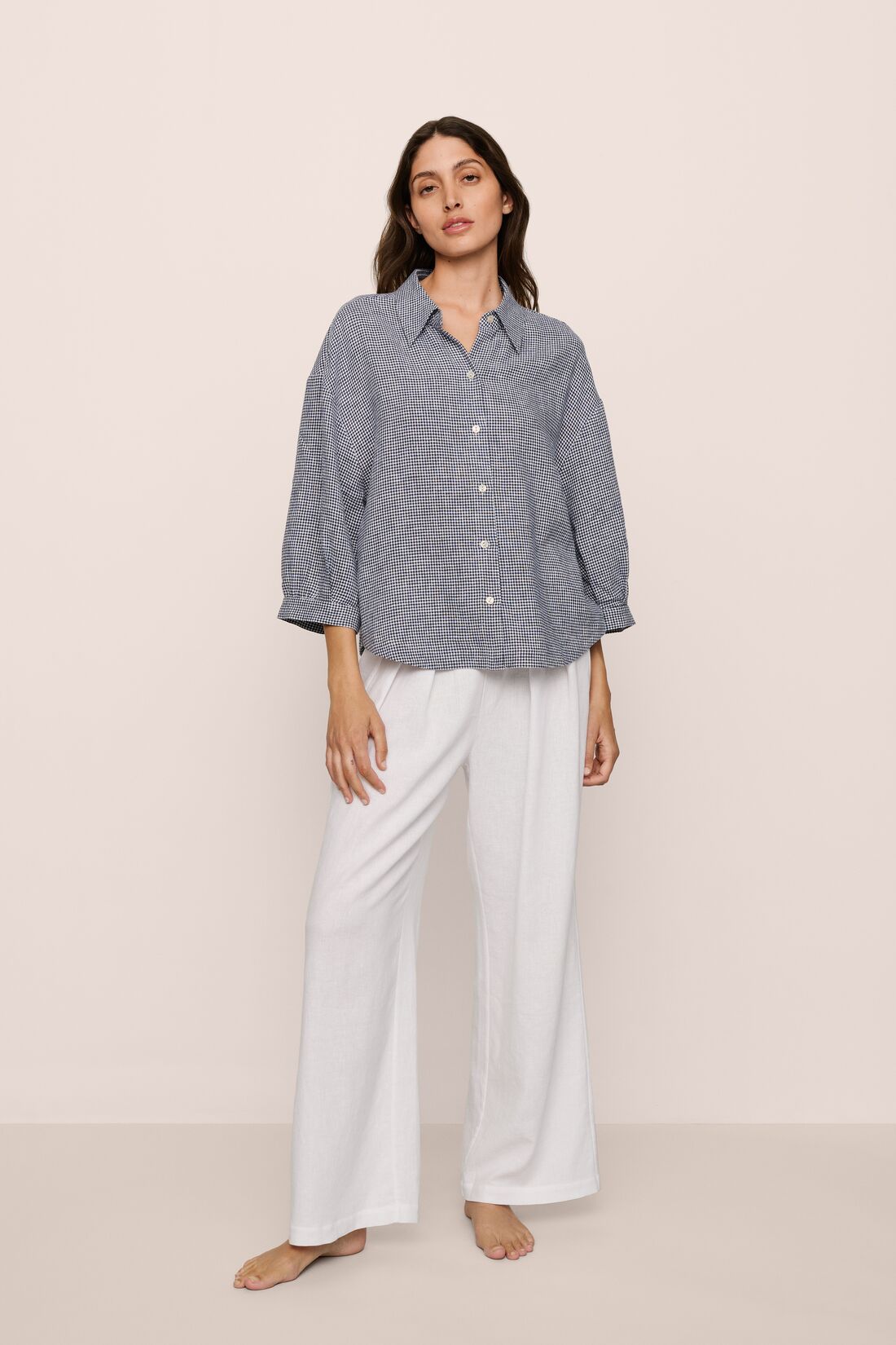 Model is wearing relaxed quarter sleeve  top in gingham white/navy