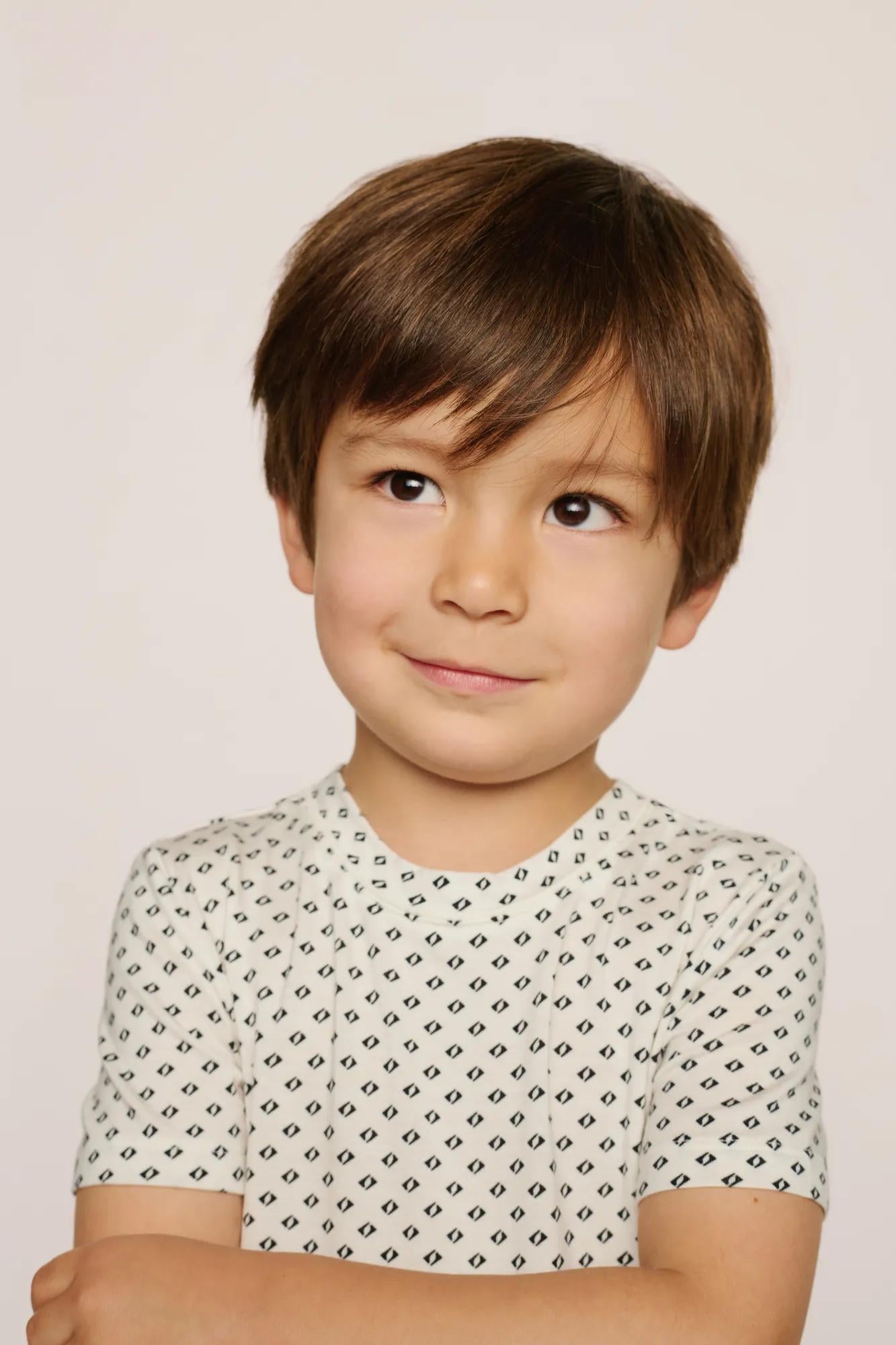 Model is wearing Kids Printed TENCEL™ Modal Unisex Short PJ Set in Tide Dot Ivory/Ivory
