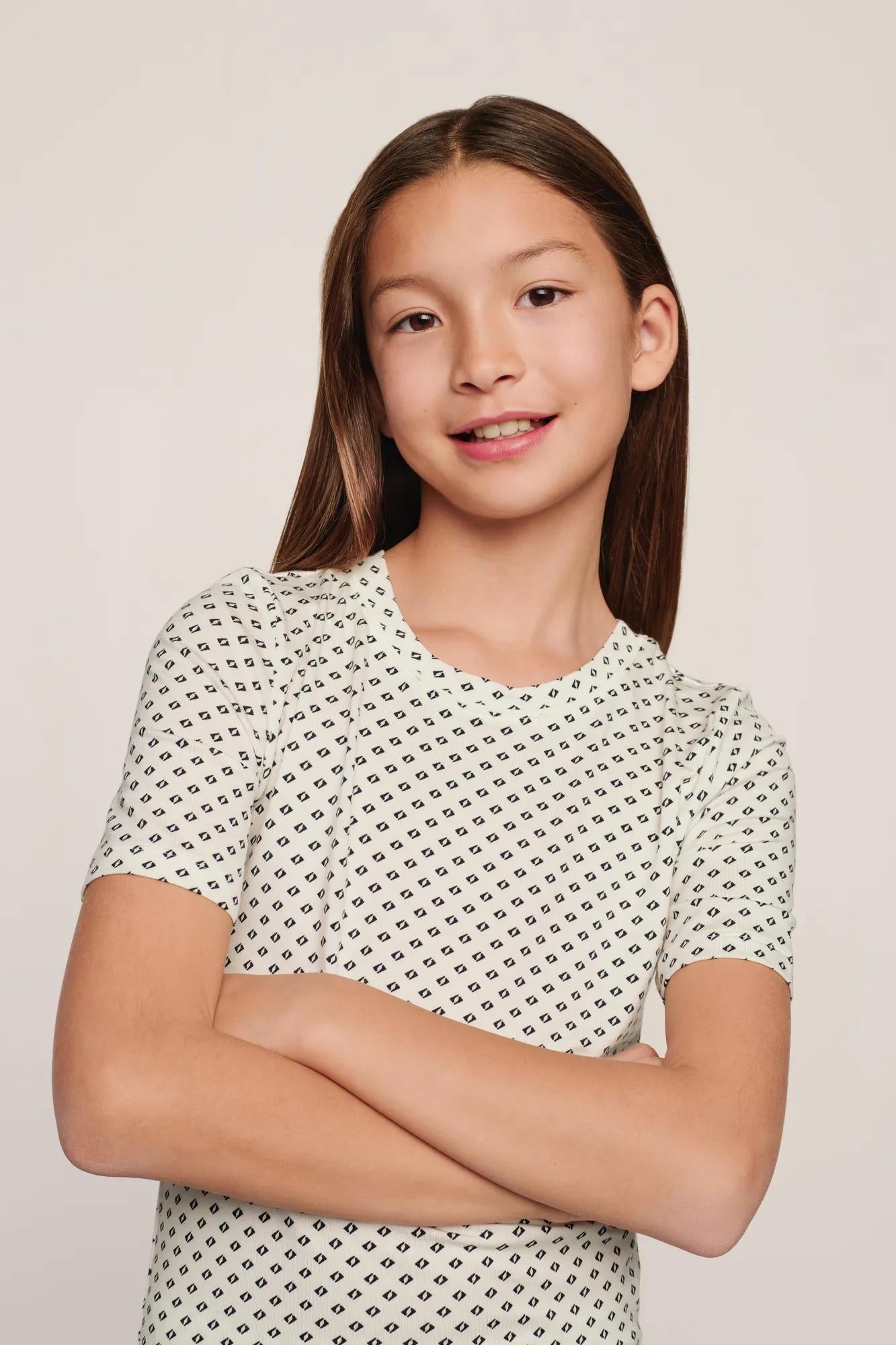 Model is wearing Kids Printed TENCEL™ Modal Unisex Short PJ Set in Tide Dot Ivory/Ivory