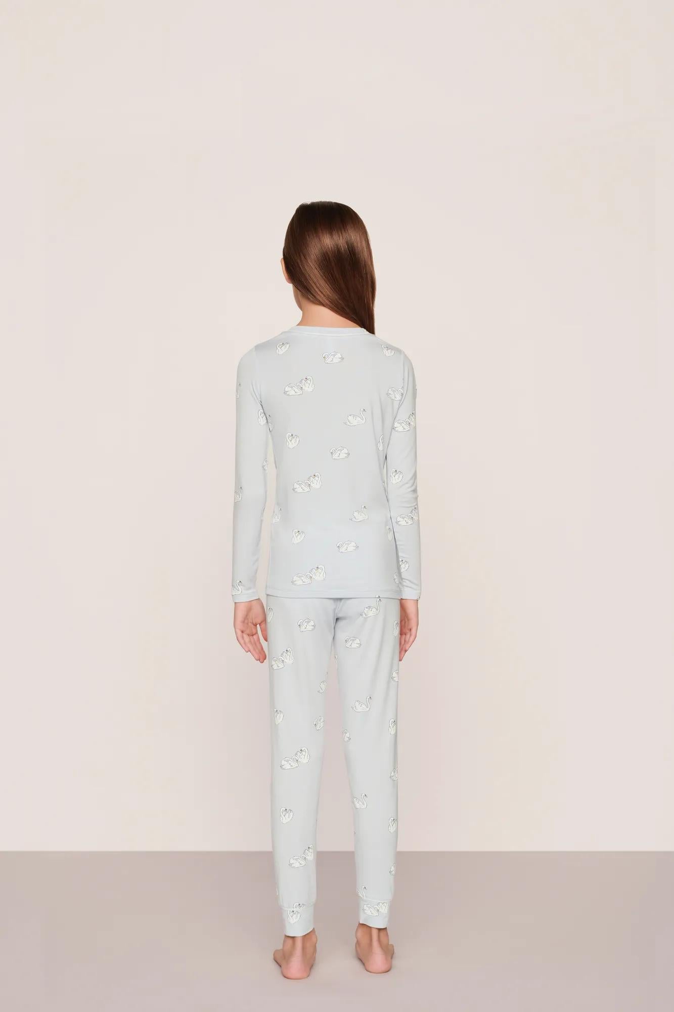 Model is wearing Kids Printed TENCEL™ Modal Unisex Long PJ Set in Large Swans Ice Blue/Ivory