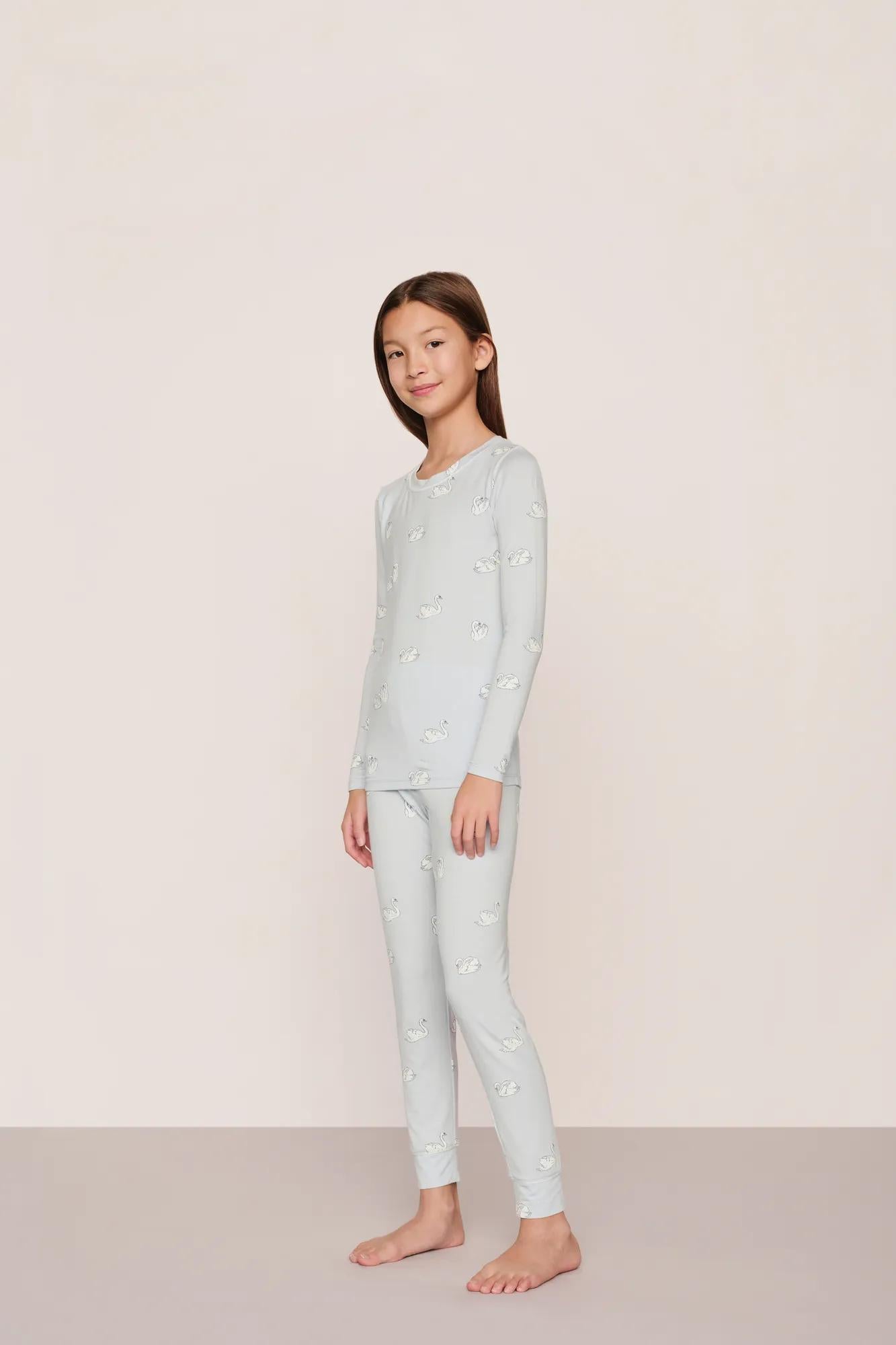 Model is wearing Kids Printed TENCEL™ Modal Unisex Long PJ Set in Large Swans Ice Blue/Ivory