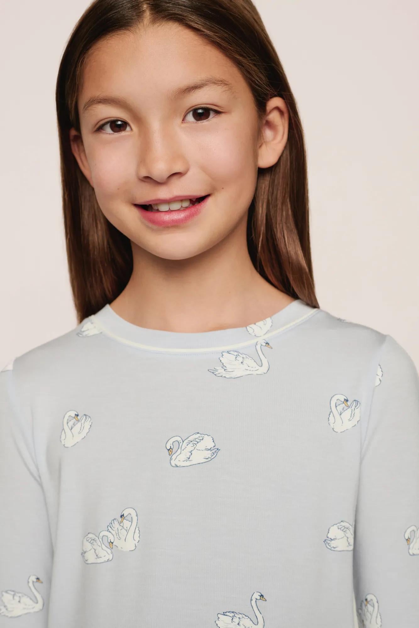 Model is wearing Kids Printed TENCEL™ Modal Unisex Long PJ Set in Large Swans Ice Blue/Ivory