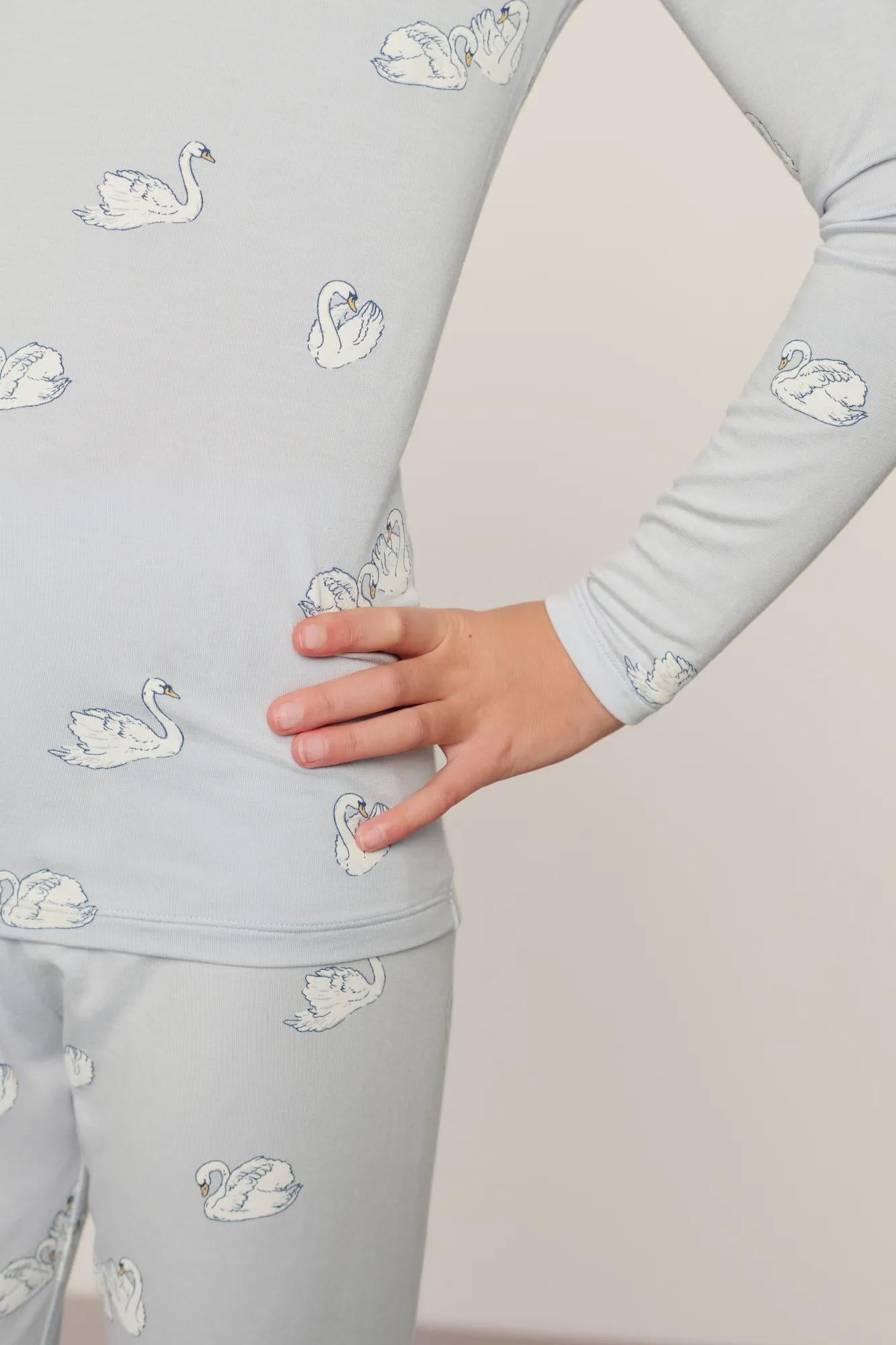 Model is wearing Kids Printed TENCEL™ Modal Unisex Long PJ Set in Large Swans Ice Blue/Ivory