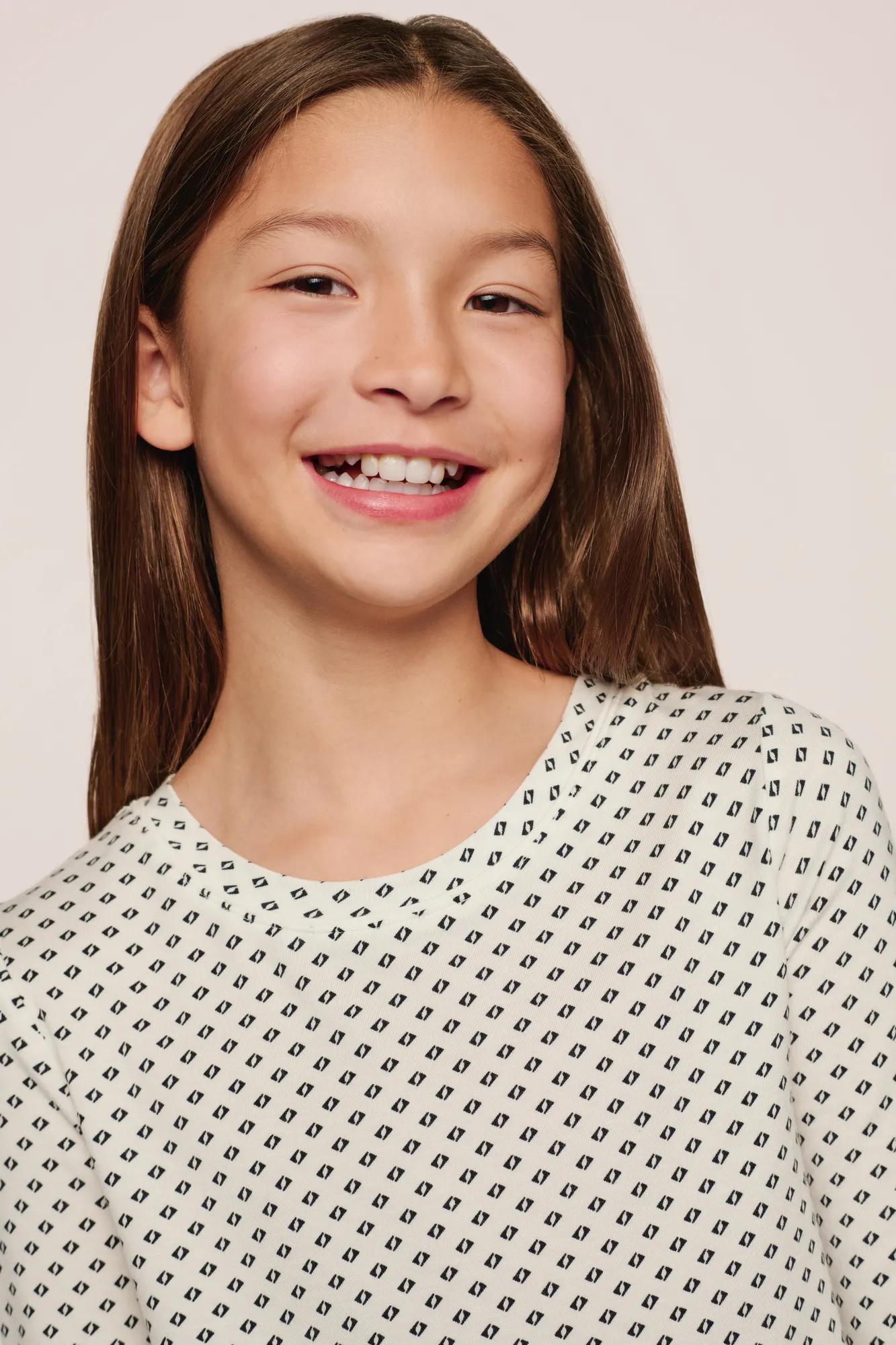 Model is wearing Kids Printed TENCEL™ Modal Unisex Long PJ Set in Tide Dot Ivory/Ivory