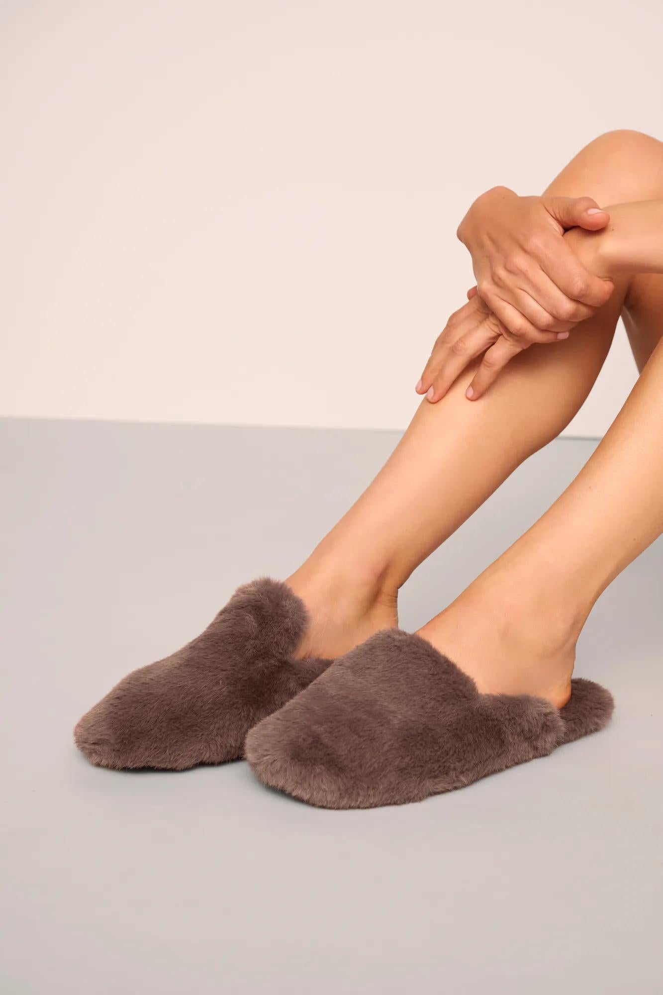 Model is wearing Plush Mule Slipper  in  Deep Taupe